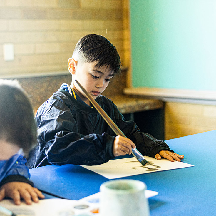 Boy painting at St Josephs Catholic Primary Kingwood